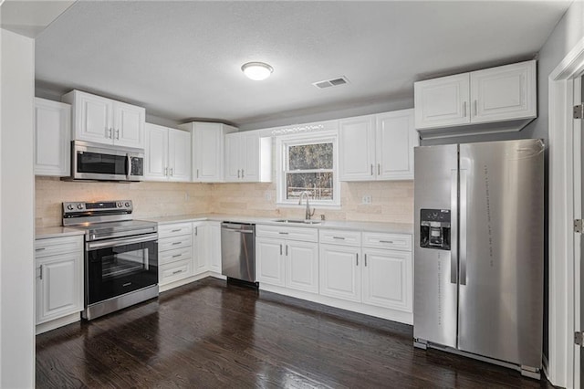 kitchen with white cabinetry, appliances with stainless steel finishes, sink, and decorative backsplash