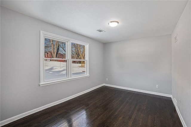 spare room featuring dark wood-type flooring