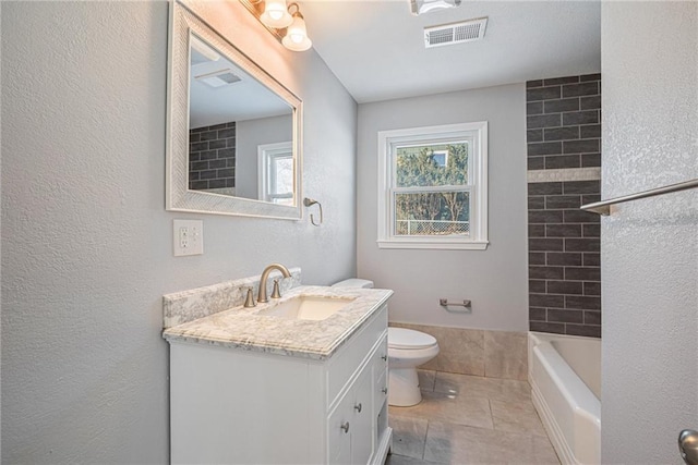 full bathroom with tile patterned flooring, vanity, tiled shower / bath combo, and toilet