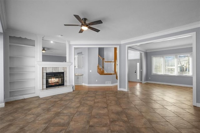 unfurnished living room with ceiling fan, ornamental molding, a fireplace, and built in features