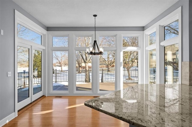 unfurnished sunroom with a chandelier