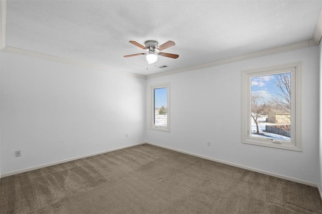 carpeted empty room with crown molding, plenty of natural light, and ceiling fan