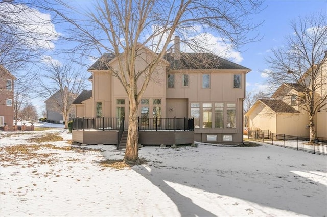 snow covered rear of property featuring a deck