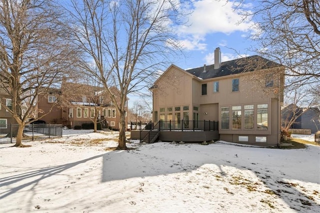 snow covered house featuring a wooden deck