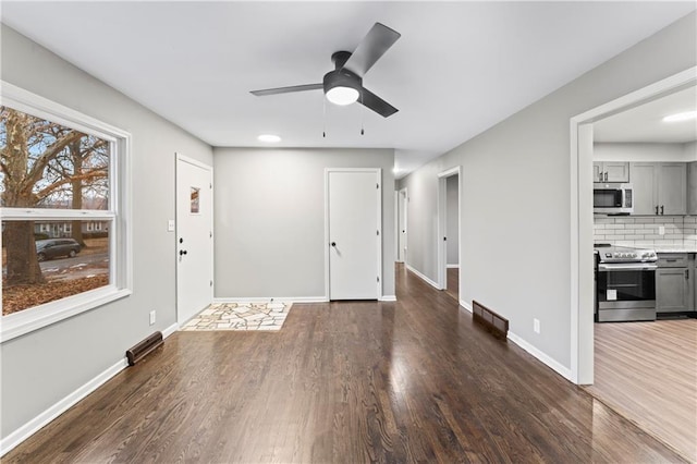 foyer entrance with ceiling fan and dark hardwood / wood-style floors