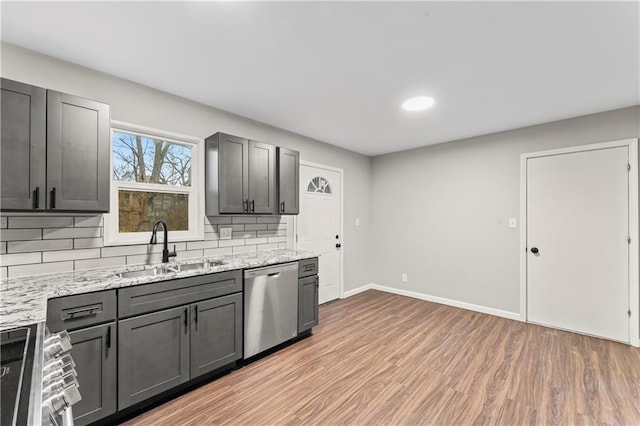 kitchen featuring sink, gray cabinetry, tasteful backsplash, light wood-type flooring, and stainless steel appliances