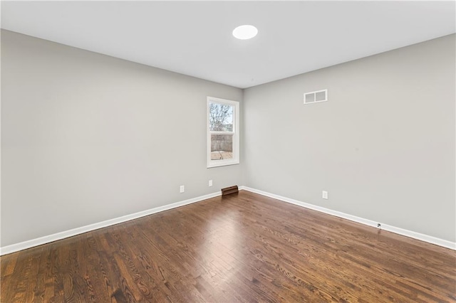 unfurnished room with dark wood-type flooring