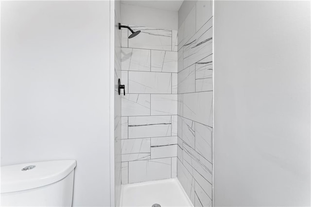 bathroom with toilet and tiled shower