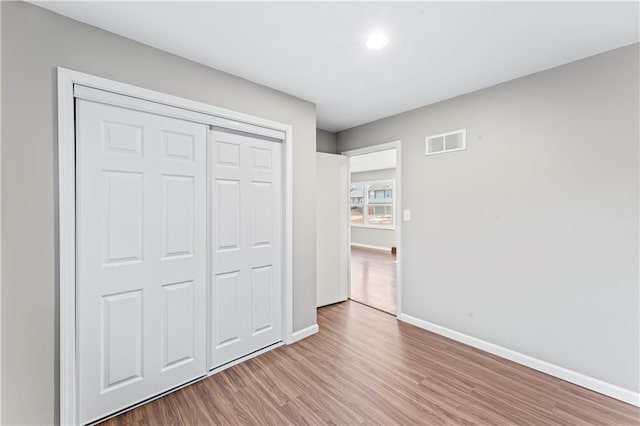 unfurnished bedroom with light hardwood / wood-style floors and a closet