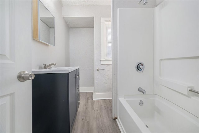 bathroom featuring hardwood / wood-style flooring, vanity, and shower / bathing tub combination