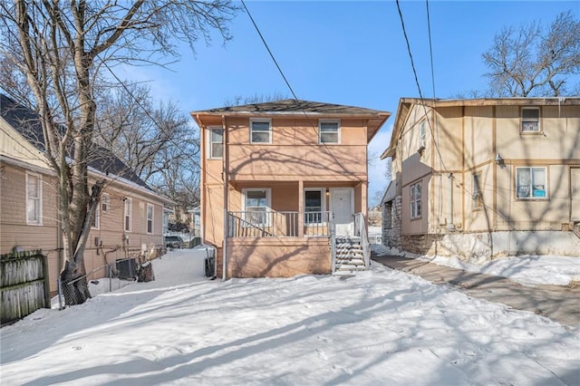 snow covered property featuring central AC unit and covered porch