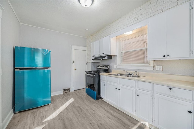 2463 Denver Ave, Kansas City, MO 64127 - kitchen featuring black range oven, refrigerator, light wood finished floors, white cabinetry, and a textured ceiling