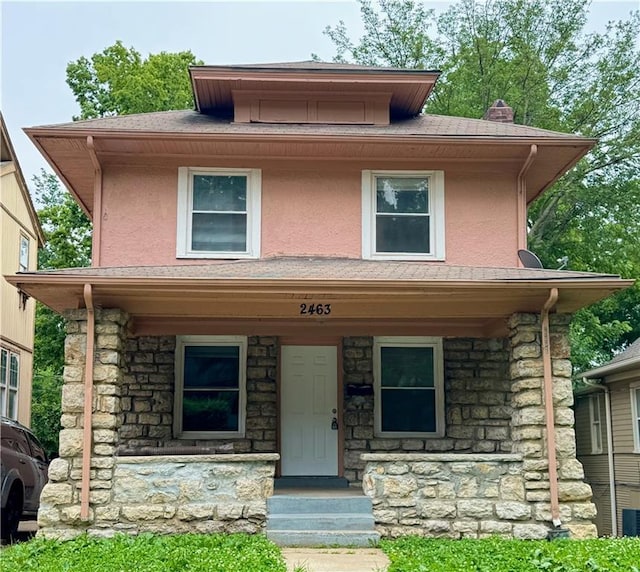 2463 Denver Ave, Kansas City, MO 64127 - traditional style home with stone siding, stucco siding, a chimney, and covered porch