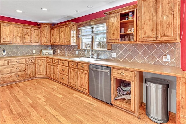 kitchen featuring tasteful backsplash, sink, stainless steel dishwasher, and light hardwood / wood-style floors