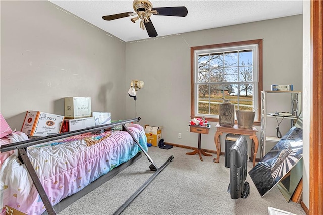 carpeted bedroom with ceiling fan and a textured ceiling