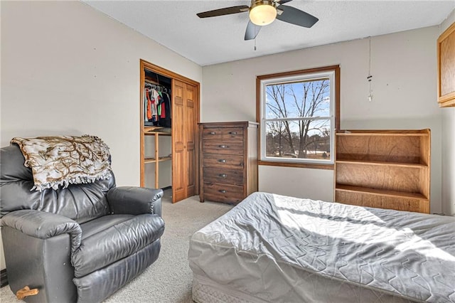 carpeted bedroom with ceiling fan and a closet