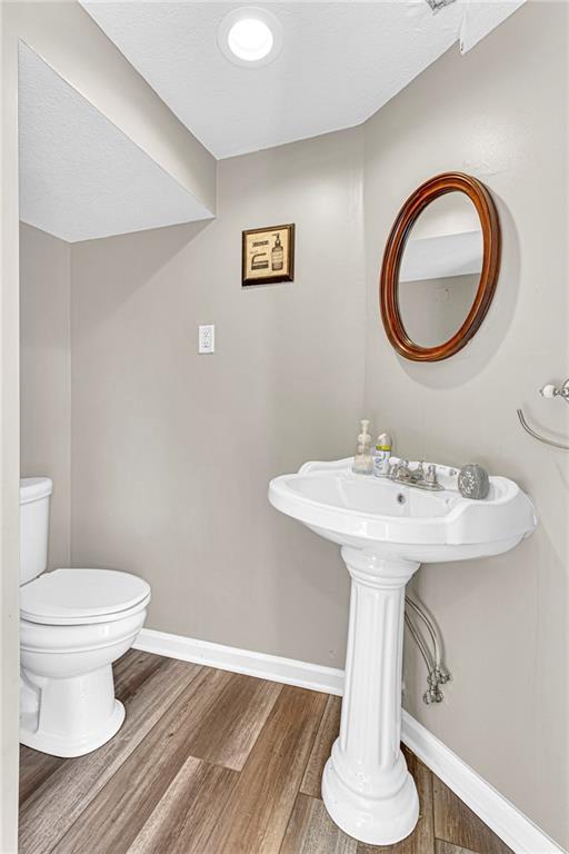 bathroom with hardwood / wood-style floors and toilet