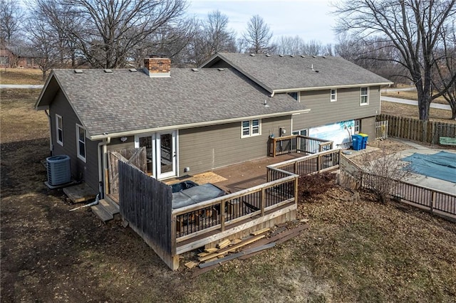 back of house featuring central AC and a swimming pool side deck