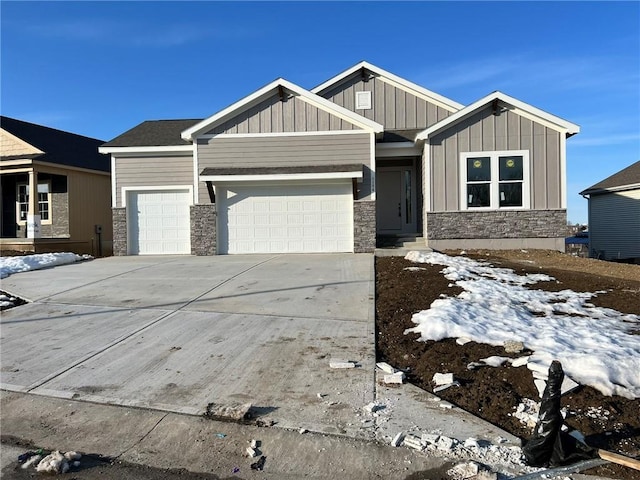 craftsman inspired home featuring stone siding, concrete driveway, board and batten siding, and an attached garage