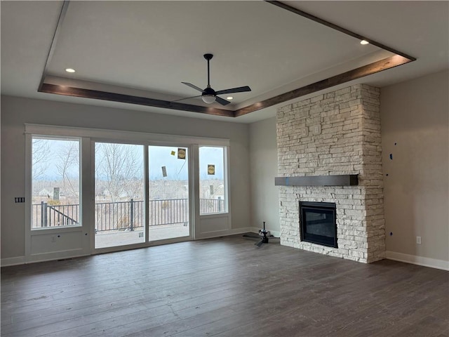 unfurnished living room featuring a raised ceiling and wood finished floors