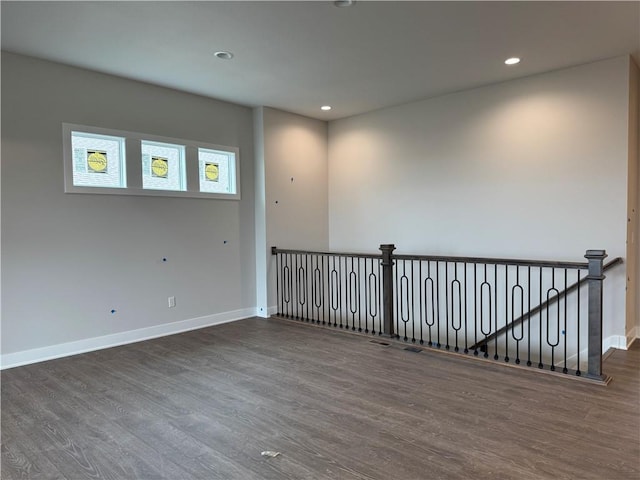 spare room featuring baseboards, dark wood-type flooring, and recessed lighting