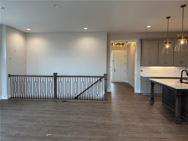 kitchen featuring dark wood-style floors, decorative light fixtures, light countertops, backsplash, and recessed lighting