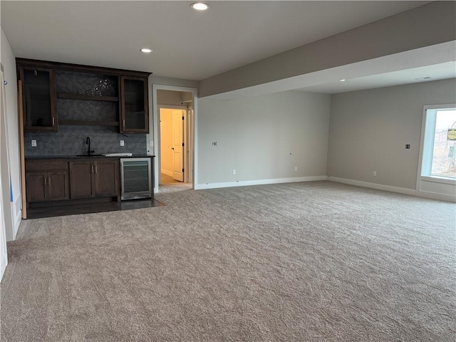 interior space featuring wine cooler, indoor wet bar, recessed lighting, light carpet, and a sink