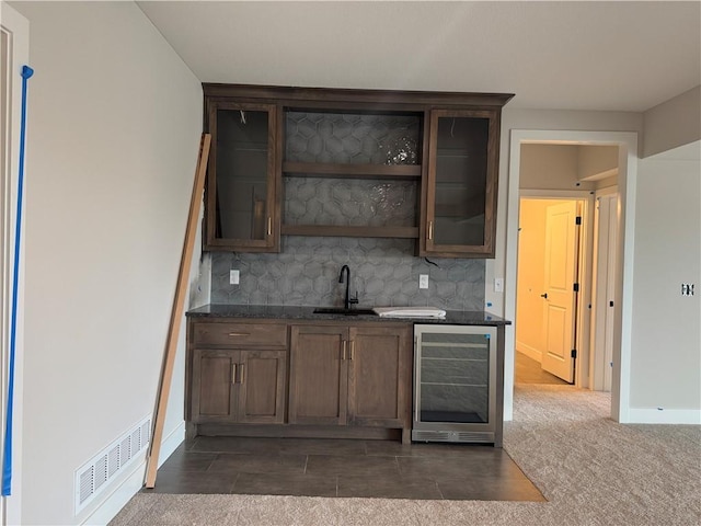 bar featuring wine cooler, a sink, visible vents, baseboards, and decorative backsplash