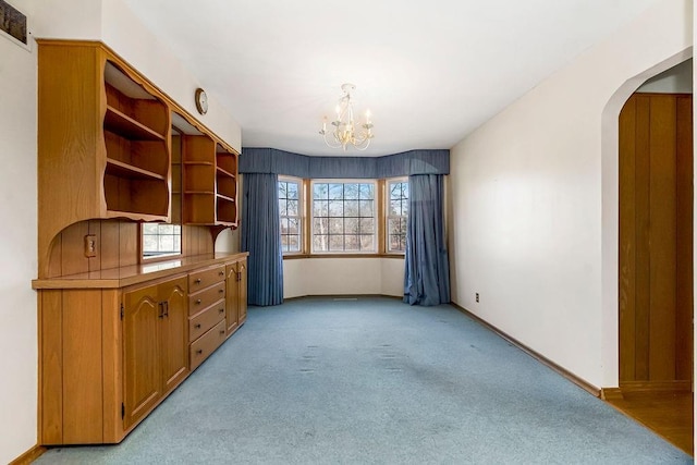 unfurnished office featuring light carpet and a chandelier