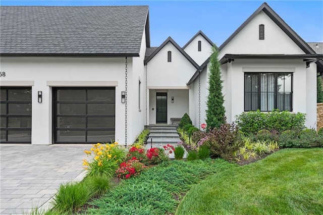 9358 Juniper Reserve Dr, Prairie Village, KS 66207 - view of front of home with stucco siding, decorative driveway, an attached garage, and a front lawn