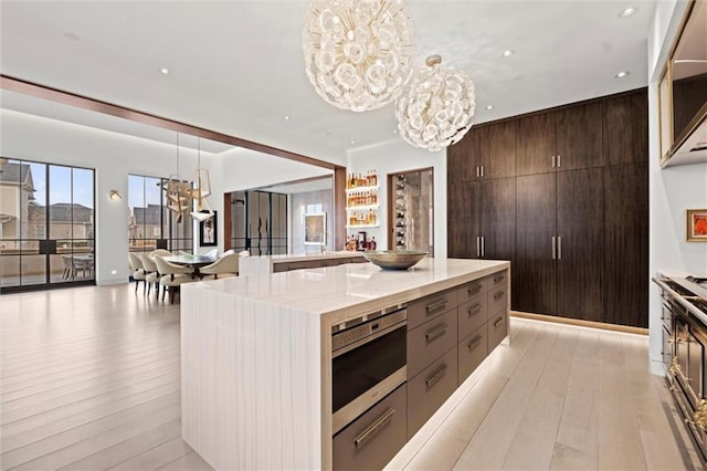 9358 Juniper Reserve Dr, Prairie Village, KS 66207 - kitchen featuring a chandelier, light wood-style floors, decorative light fixtures, modern cabinets, and recessed lighting
