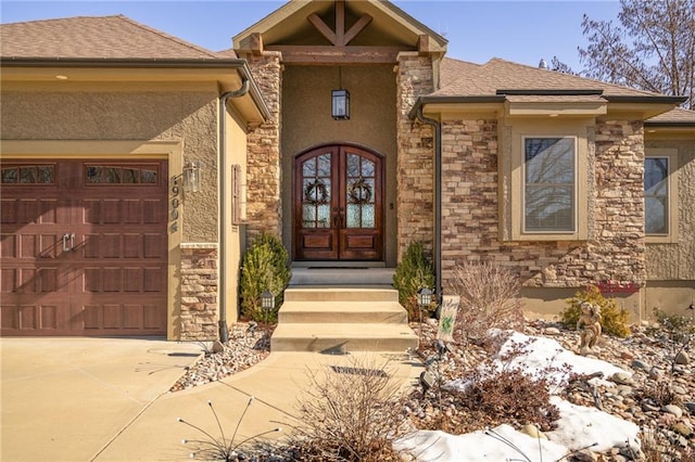 snow covered property entrance with a garage and french doors