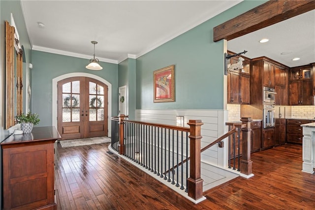 foyer entrance featuring crown molding, dark wood-type flooring, and french doors