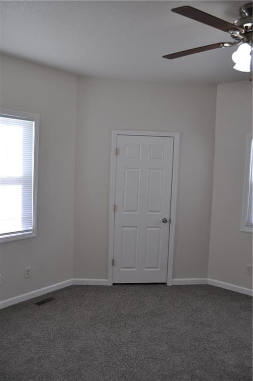 carpeted empty room featuring ceiling fan