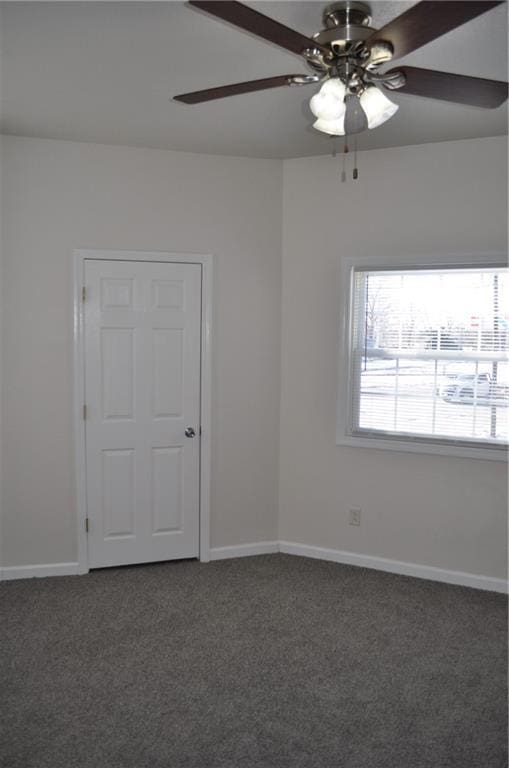 carpeted spare room featuring ceiling fan