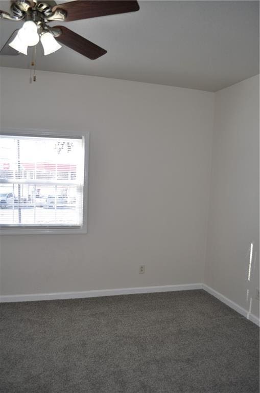 unfurnished room featuring ceiling fan and dark carpet