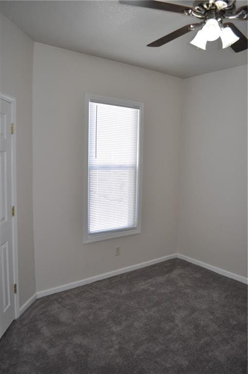 empty room featuring dark carpet and ceiling fan