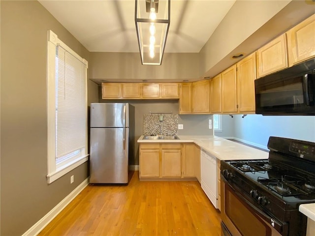 kitchen featuring light brown cabinetry, sink, black appliances, and light wood-type flooring