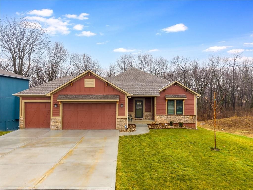 craftsman-style home featuring a garage and a front lawn