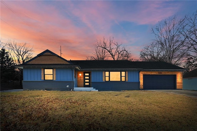 view of front of property featuring a garage and a lawn