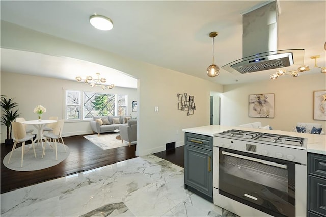 kitchen with island range hood, decorative light fixtures, gas stove, and a notable chandelier