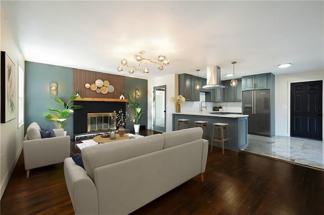 living room with dark hardwood / wood-style floors, sink, and a brick fireplace