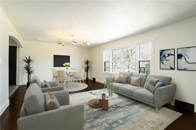 living room featuring dark wood-type flooring and an inviting chandelier