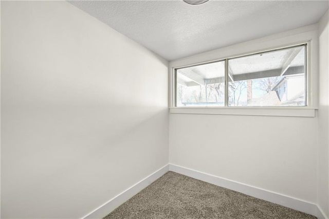 carpeted empty room featuring a textured ceiling