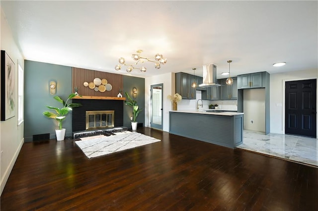 living room featuring sink, a fireplace, and dark hardwood / wood-style floors