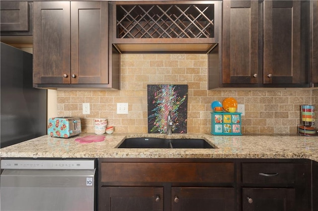 kitchen featuring tasteful backsplash, light stone countertops, dishwasher, and dark brown cabinets