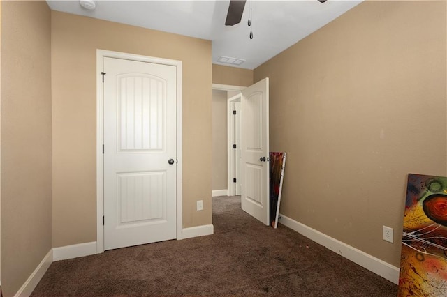 unfurnished bedroom featuring ceiling fan and dark carpet