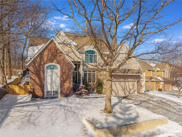 view of front of property with driveway, a garage, fence, and brick siding