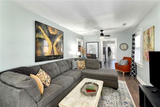 living room featuring dark wood-type flooring and ceiling fan