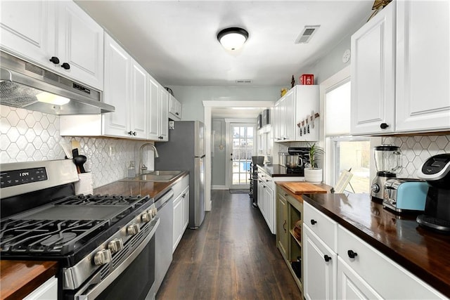 kitchen with sink, white cabinetry, butcher block counters, stainless steel appliances, and dark hardwood / wood-style flooring